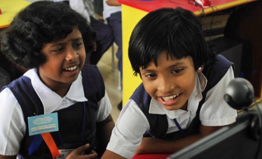 Students at the School in the Cloud in India excitedly figure out how to use a computer. Photo: Courtesy of Jerry Rothwell